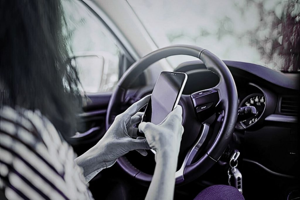 Woman sitting in car at night reading a message on her phone, emotional and uncertain moment